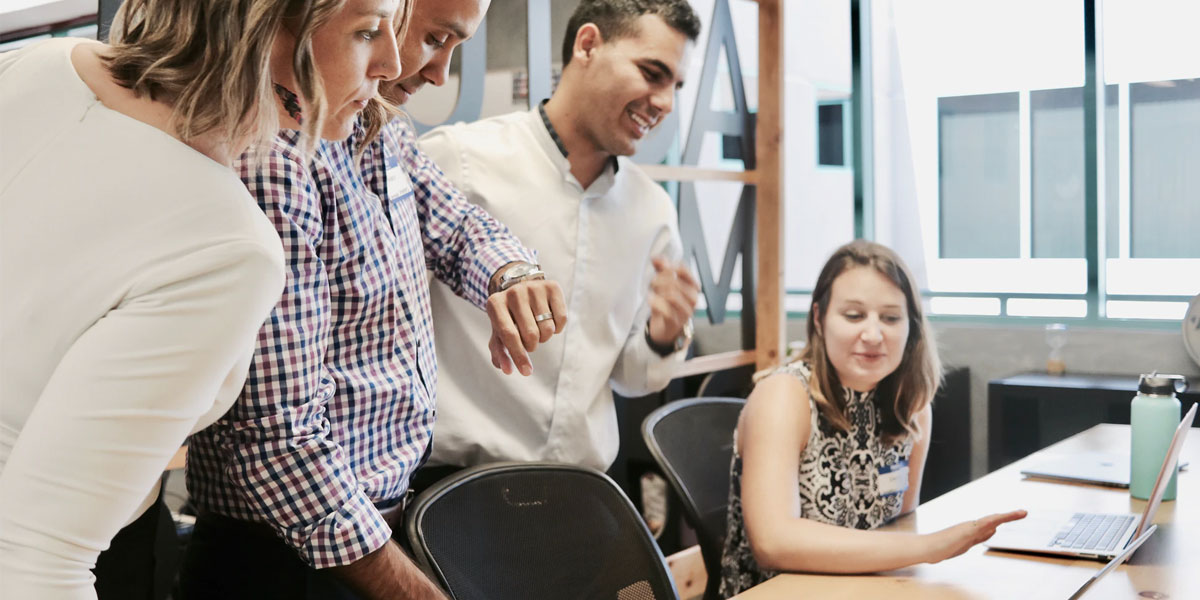 Principal and staff working over a computer